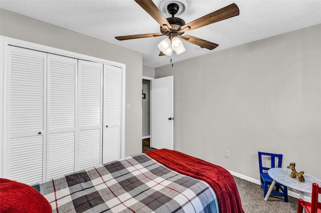 carpeted bedroom with a closet, ceiling fan, and a textured ceiling