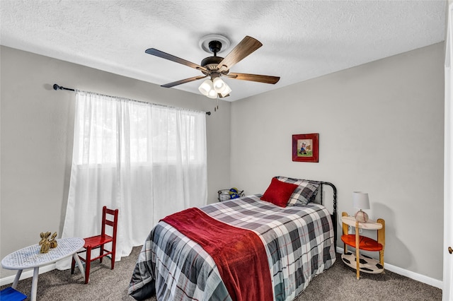 bedroom with ceiling fan, carpet flooring, and a textured ceiling