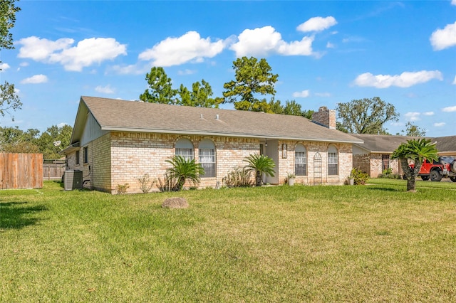 ranch-style home featuring cooling unit and a front yard