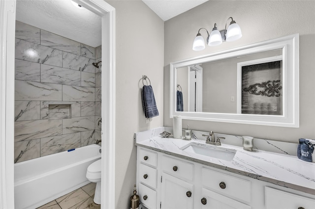 full bathroom with tiled shower / bath, vanity, toilet, and a textured ceiling