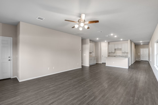 unfurnished living room featuring dark hardwood / wood-style flooring and ceiling fan