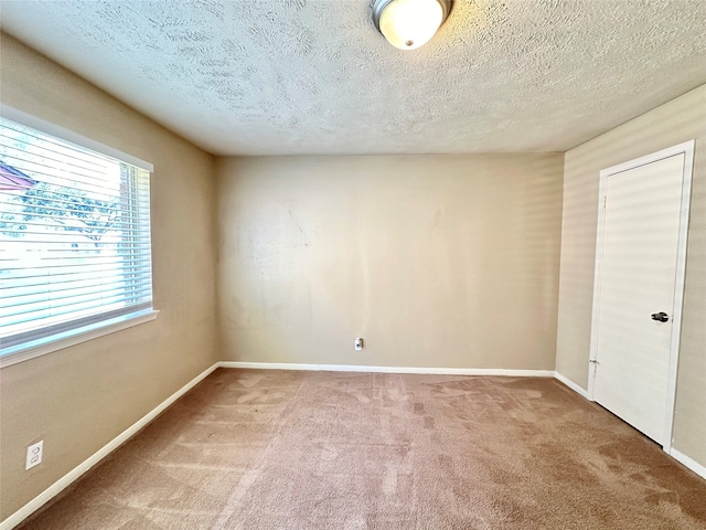 unfurnished room with a textured ceiling and carpet flooring