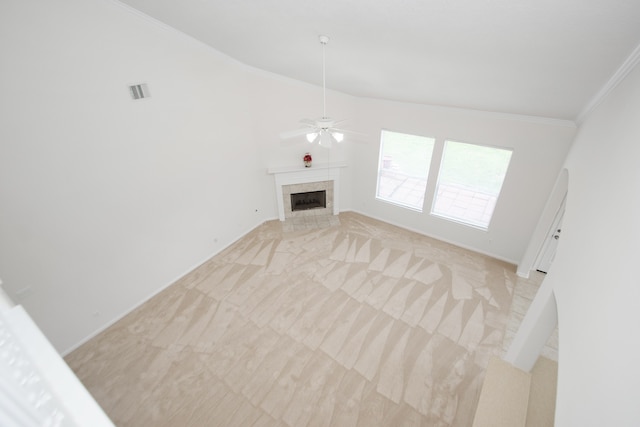 unfurnished living room featuring vaulted ceiling, a fireplace, crown molding, ceiling fan, and light carpet