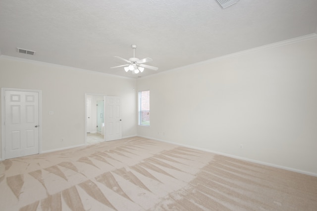 unfurnished room with a textured ceiling, crown molding, ceiling fan, and light carpet