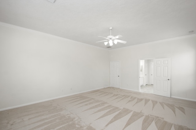 spare room with ceiling fan, light carpet, and ornamental molding