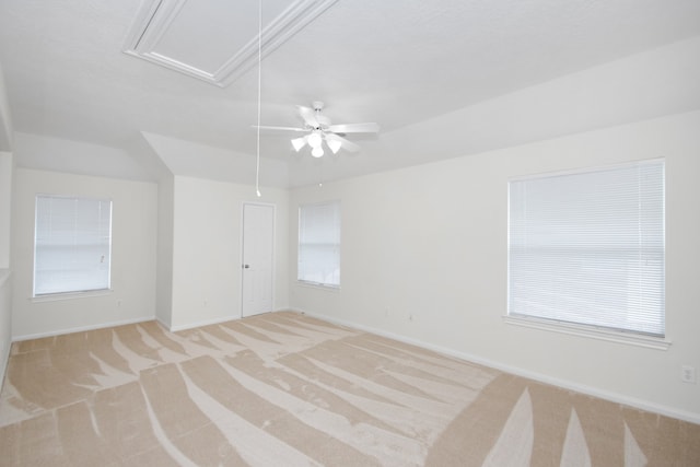 spare room featuring ceiling fan, light carpet, and a wealth of natural light