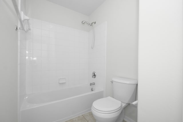 bathroom with toilet, tile patterned floors, and tiled shower / bath