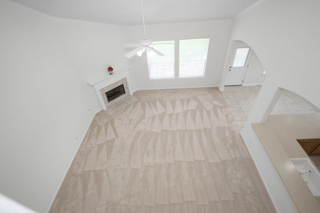 unfurnished living room with ceiling fan and crown molding