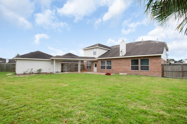 back of house with a yard and a patio