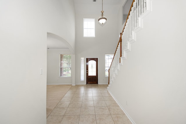 tiled entryway featuring a high ceiling