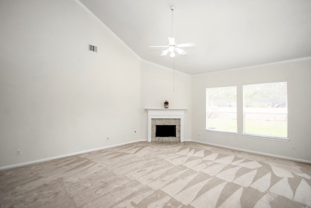 unfurnished living room featuring ceiling fan, light colored carpet, a fireplace, and crown molding