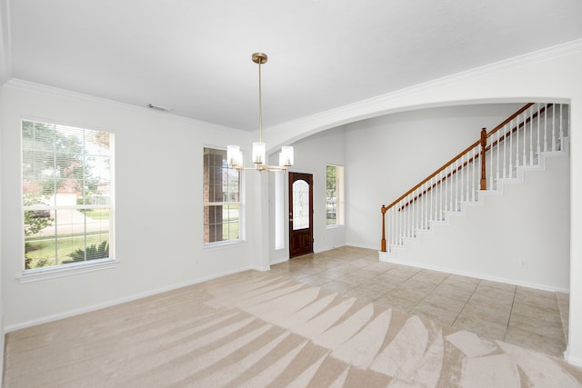 foyer featuring a healthy amount of sunlight, ornamental molding, light carpet, and a notable chandelier