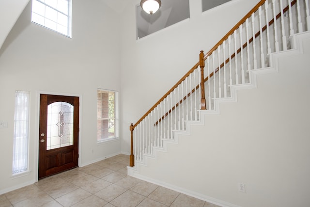 tiled entryway with a towering ceiling