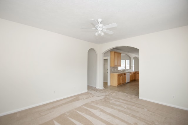 spare room with light carpet, ceiling fan, and sink