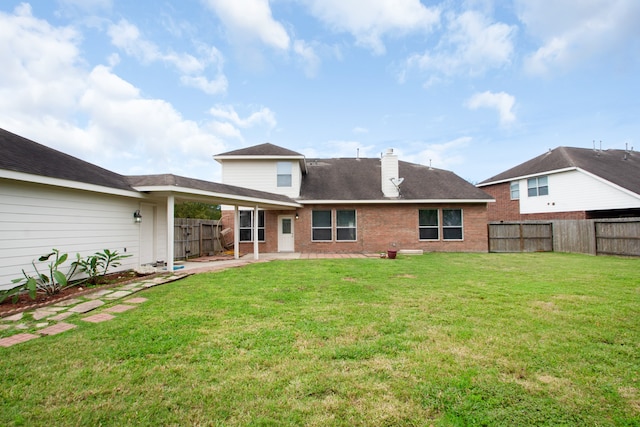 rear view of property with a yard and a patio