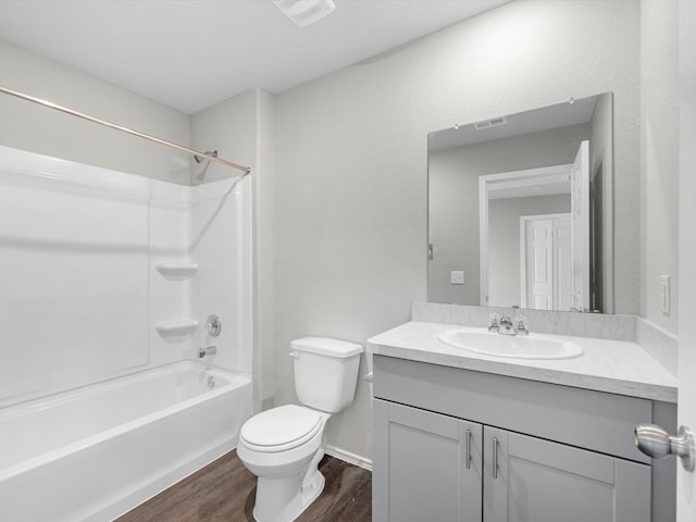 full bathroom with shower / bathing tub combination, vanity, hardwood / wood-style floors, and toilet