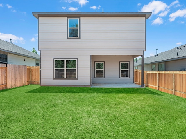 rear view of house featuring a lawn and a patio area