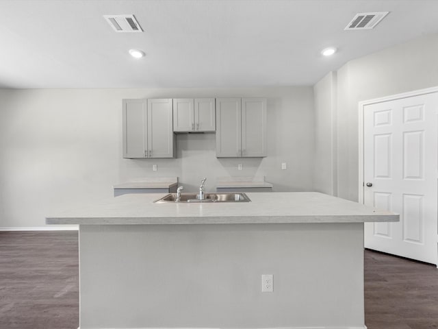 kitchen featuring a center island with sink, dark hardwood / wood-style floors, sink, and gray cabinets