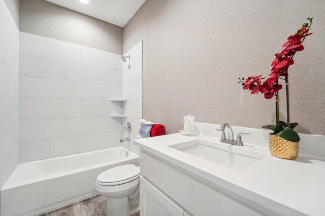 full bathroom with tiled shower / bath combo, vanity, toilet, and wood-type flooring