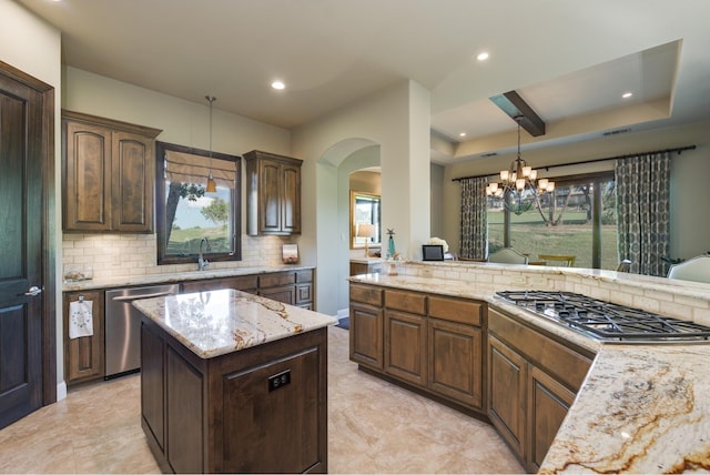 kitchen featuring pendant lighting, sink, decorative backsplash, a center island, and stainless steel appliances