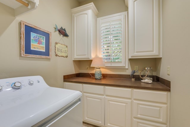 clothes washing area featuring cabinets and washer / clothes dryer