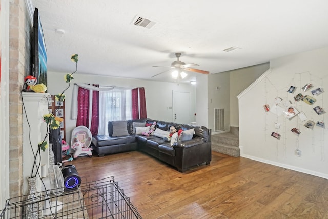 living room with ceiling fan, hardwood / wood-style floors, and a textured ceiling