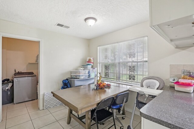 dining room with washer / dryer, a textured ceiling, and light tile patterned flooring