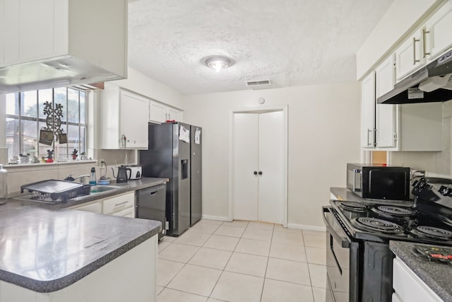 kitchen with island range hood, white cabinetry, light tile patterned floors, and stainless steel appliances