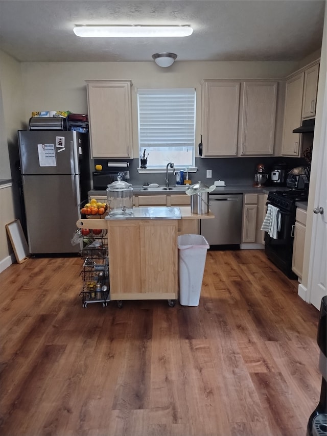 kitchen featuring a breakfast bar, dark wood-type flooring, sink, a kitchen island, and appliances with stainless steel finishes