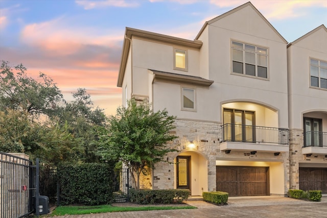 view of front of property featuring a balcony, a garage, and central AC