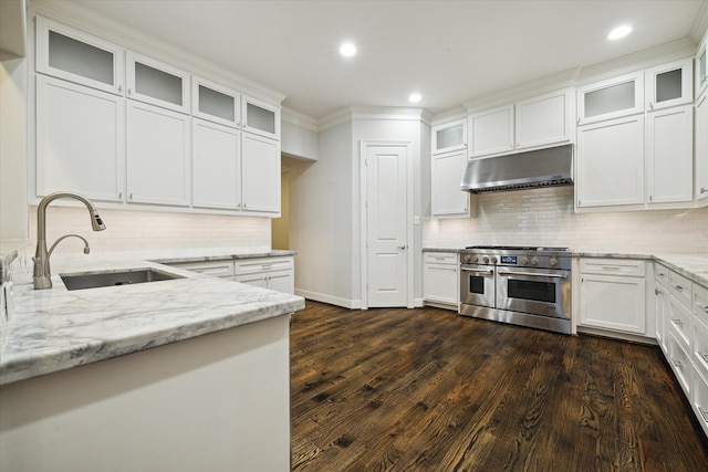 kitchen featuring white cabinets, sink, range with two ovens, light stone countertops, and dark hardwood / wood-style flooring