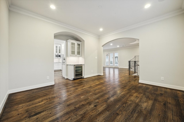 interior space featuring wine cooler, dark hardwood / wood-style floors, bar area, and crown molding