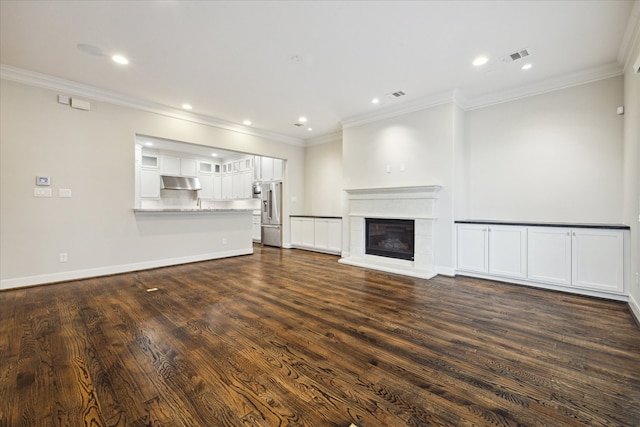 unfurnished living room featuring ornamental molding and dark hardwood / wood-style flooring