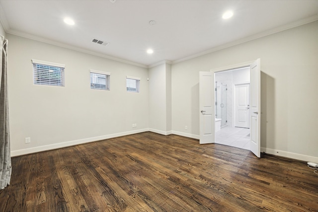 spare room featuring ornamental molding and dark hardwood / wood-style flooring