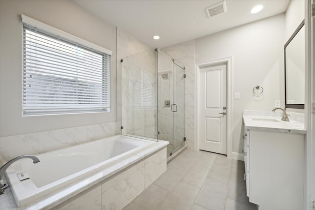 bathroom with tile patterned flooring, vanity, and separate shower and tub