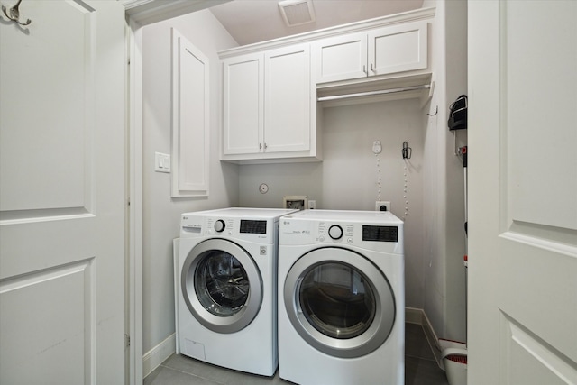 washroom with washer and clothes dryer, light tile patterned floors, and cabinets