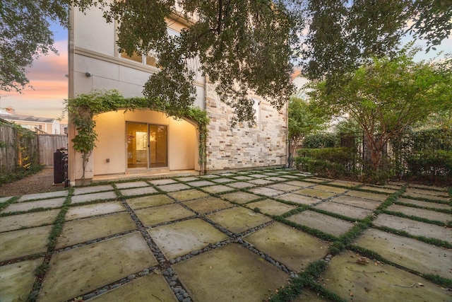 back house at dusk with a patio area