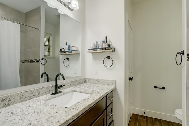 bathroom featuring a shower with shower curtain, vanity, and toilet