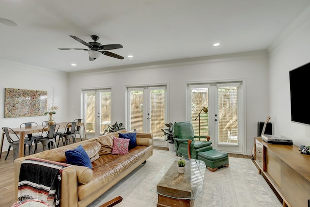 living room with french doors, light wood-type flooring, and crown molding