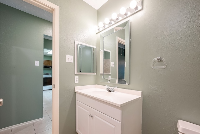 bathroom with vanity, toilet, and tile patterned floors