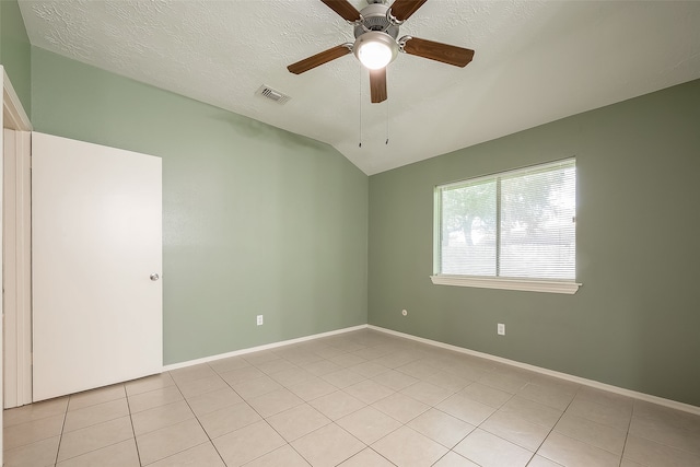 tiled spare room featuring a textured ceiling, vaulted ceiling, and ceiling fan