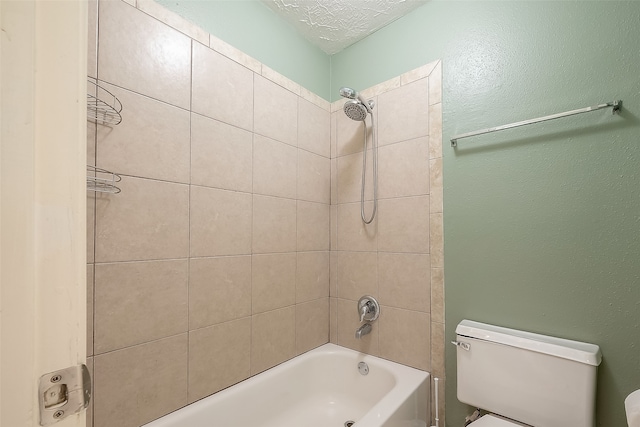 bathroom featuring a textured ceiling, tiled shower / bath combo, and toilet