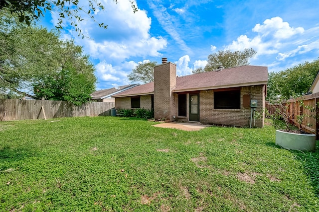 rear view of house featuring a lawn and a patio