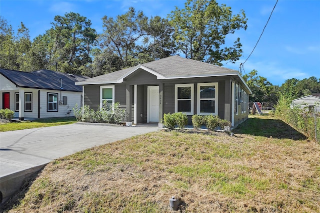 view of front of home with a front lawn and a shingled roof