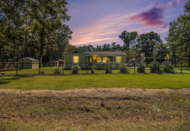 back house at dusk featuring a lawn