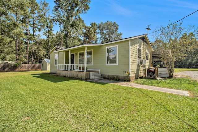 view of front of home featuring a storage unit and a front yard