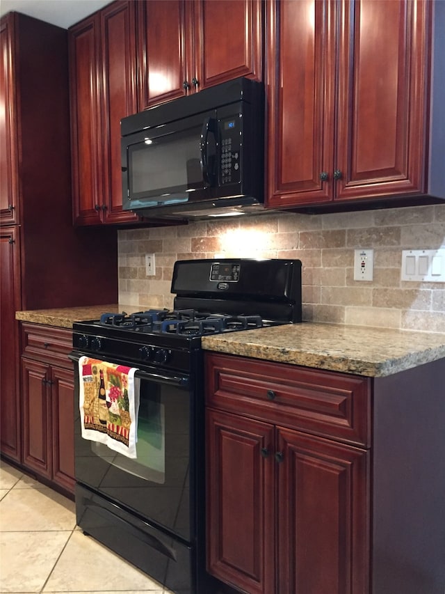 kitchen with light stone counters, backsplash, light tile patterned floors, and black appliances