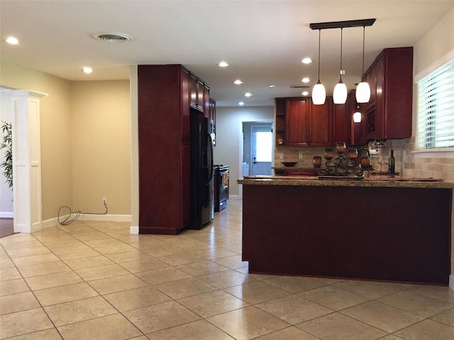 kitchen with pendant lighting, light tile patterned floors, kitchen peninsula, tasteful backsplash, and black appliances