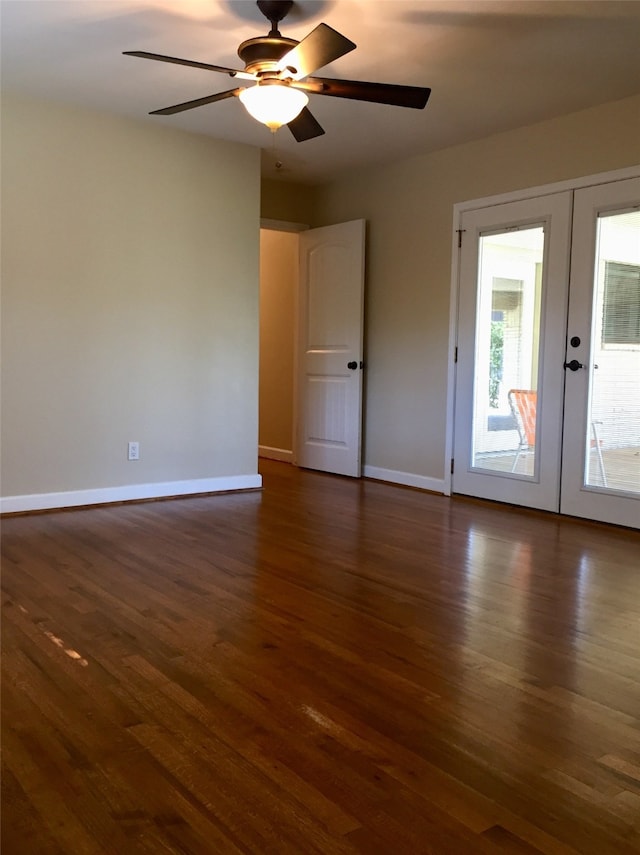 empty room with french doors, ceiling fan, and dark wood-type flooring