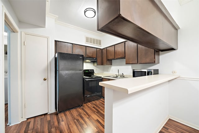 kitchen with dark brown cabinets, black appliances, and dark hardwood / wood-style flooring